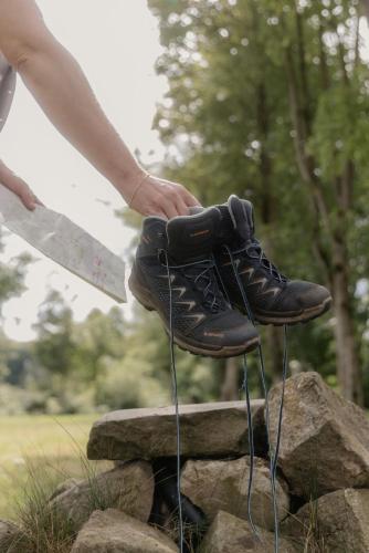 a person holding a pair of shoes on a rock at Landhotel Stähle in Schüttorf