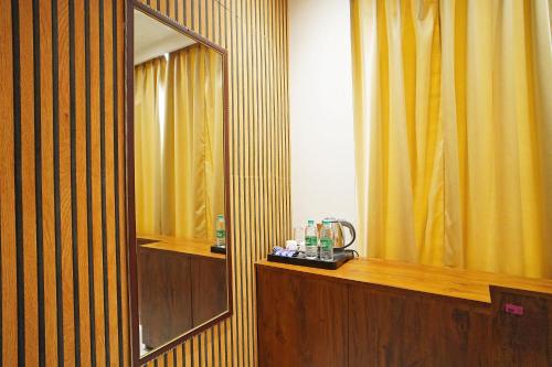 a bathroom with a mirror and a yellow curtain at Hotel Tripka Square - walking distance from Baidyanath Dham Temple in Deoghar