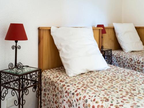 a bedroom with two beds with a pillow and a lamp at Vineyards & Village Stay in Minerve