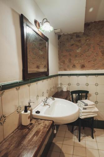 a bathroom with a white sink and a table at Casa Barría in Pradoluengo