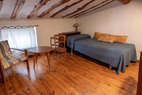a bedroom with a bed and a table and a chair at Casa Barría in Pradoluengo