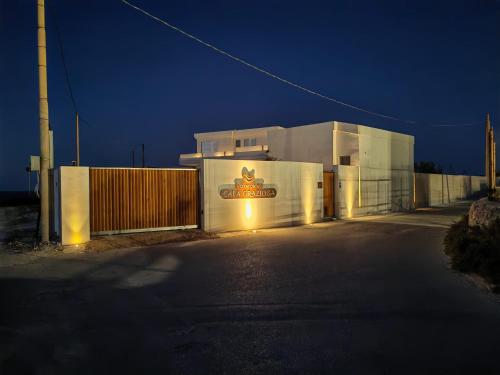 a white building with a gate at night at Dimora Cala Graziosa in Favignana