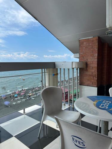 a balcony with a table and chairs and a view of the beach at Hotel George in Ureki