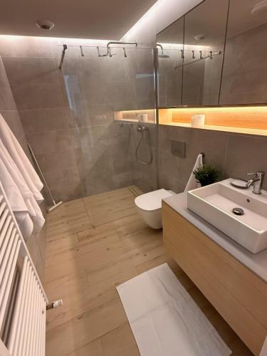 a bathroom with a shower and a toilet and a sink at Pinea Apartments in Pobierowo