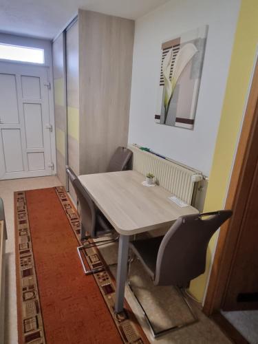 a table and chairs in a room with a door at Rooms & Apartments Jana in Cerklje na Gorenjskem