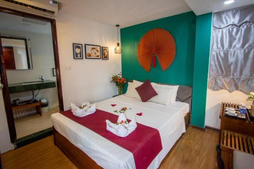 a bedroom with a bed with a green wall at NT Elysian hotel in Hanoi