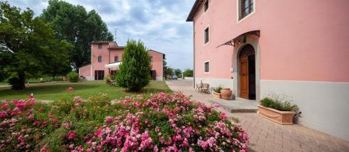 a pink building with flowers in front of it at Antico Borgo Delle Rose in Gricignano