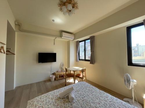 a bedroom with a bed and a table and a tv at Hello Guesthouse in Lugang