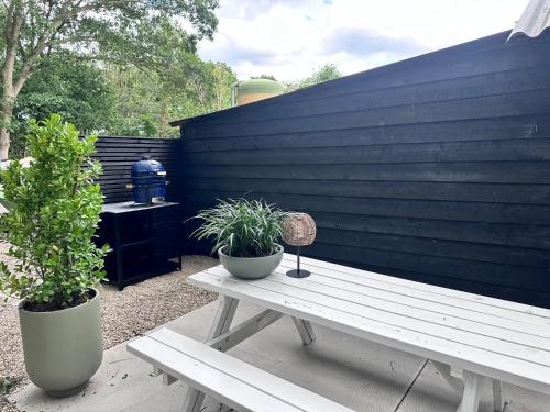 a picnic table with two potted plants next to a fence at Eikenhof in Lierop