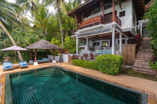 a house with a swimming pool in front of a house at Napasai Samui in Mae Nam