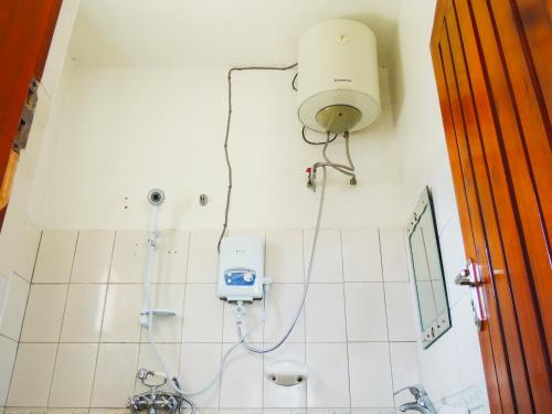ein Bad mit einer Dusche mit einem Licht an der Wand in der Unterkunft Agape House Kisoro in Kisoro