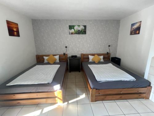 two twin beds in a room withthritisthritisthritisthritisthritisthritisthritisthritisthritis at Schönes Ferienhaus&Monteurzimmer direkt in Lich, ruhige&zentrale Lage in Lich