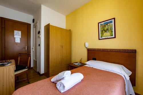 a bedroom with a large bed with two towels on it at Hotel La Chance in Saint Vincent