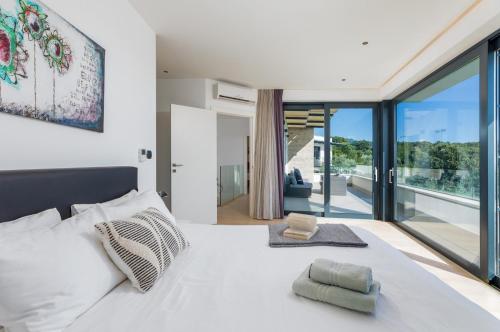 una camera da letto con un letto bianco e una grande finestra di Villa Sara a Vrsar