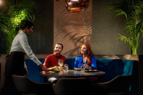 a man and woman sitting at a table in a restaurant at Clayton Hotel Charlemont in Dublin