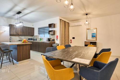 マルサスカーラにあるIl-Girna- Modern Seaside Accommodationのダイニングルーム、キッチン(テーブル、椅子付)