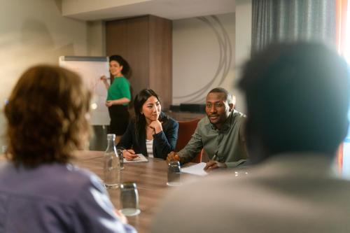a group of people sitting around a table in a meeting at Clayton Hotel Charlemont in Dublin