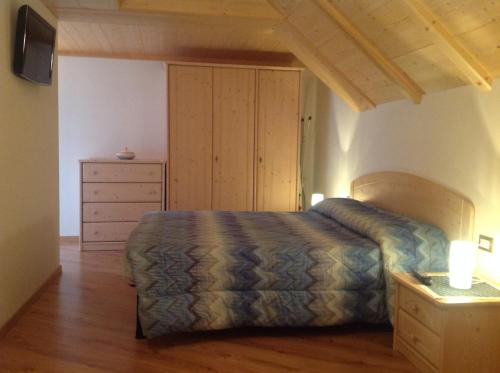 a bedroom with a bed and a dresser at Appartamenti Piazzi in Tesero