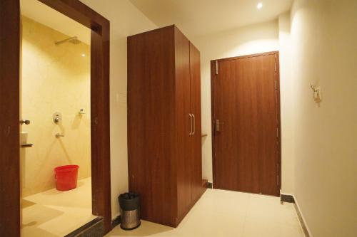 a bathroom with a shower and a wooden door at Hotel Tripka Square - walking distance from Baidyanath Dham Temple in Deoghar