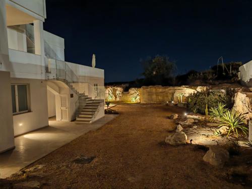 a white building with a staircase next to a yard at night at Dimora Cala Graziosa in Favignana