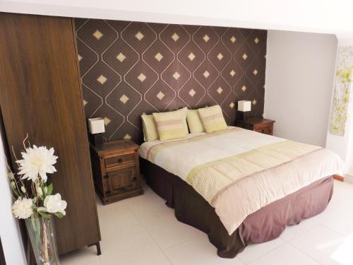 a bedroom with a bed and two tables and a vase with flowers at Villa Bellavista in Alicante