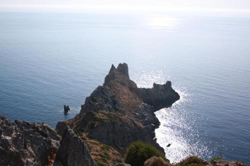a person standing on a rock in the ocean at Majori in Fluminimaggiore