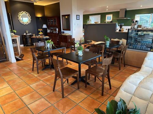 a dining room with tables and chairs in a restaurant at River Rock Retreat in Maroochy River
