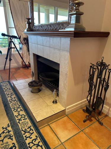 a fireplace with a mirror on top of it at River Rock Retreat in Maroochy River