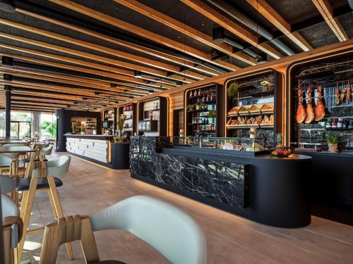 a restaurant with a bar with tables and chairs at Boutique Guesthouse - Marina Monfalcone in Monfalcone