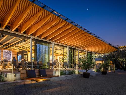 a building with a wooden pergola with benches and tables at Boutique Guesthouse - Marina Monfalcone in Monfalcone