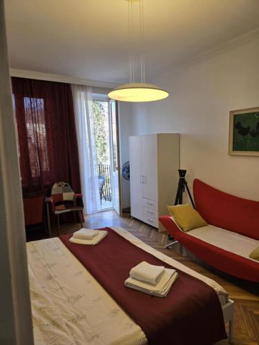 a bedroom with a large bed and a red couch at Cozy home office in Vake in Tbilisi City