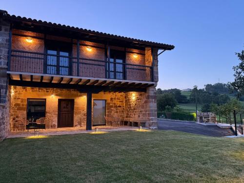 a stone house with a lawn in front of it at Zurita Rural Suites in Zurita