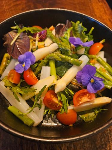 a bowl of vegetables with flowers on a table at Hotel Groede in Groede