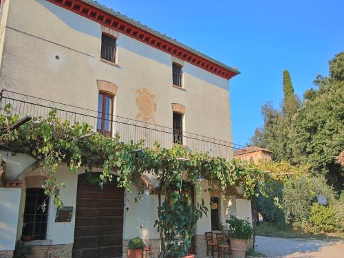 a building with vines growing on the side of it at Raffinée Farmhouse with pool views in Umbertide
