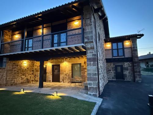 a stone house with a patio and a balcony at Zurita Rural Suites in Zurita