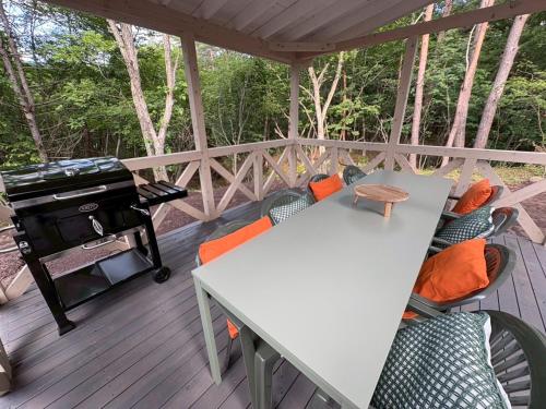 a screened in porch with a grill and a table and chairs at Second House kukka in Naganohara