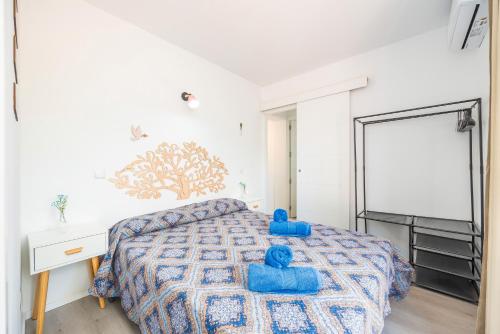 a bedroom with a bed with blue pillows on it at Gran Sol Family 2 in Felanitx