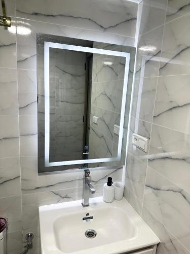 a white bathroom with a sink and a mirror at Appart hicham1 in Tangier