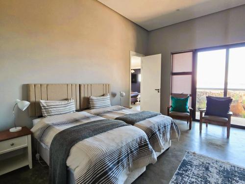a bedroom with a large bed with a large window at House 427 Windspur Estate in Nottingham Road