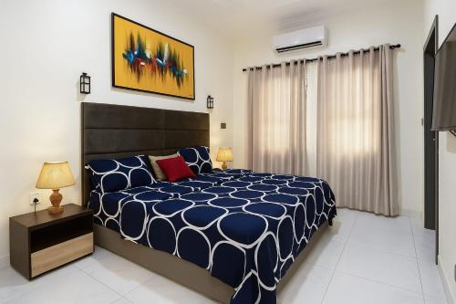 une chambre avec un lit avec une couette bleue et blanche dans l'établissement Ginik Suite And Apartments, à Lagos
