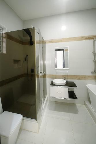 a bathroom with a shower and a sink and a toilet at Ginik Suite And Apartments in Lagos