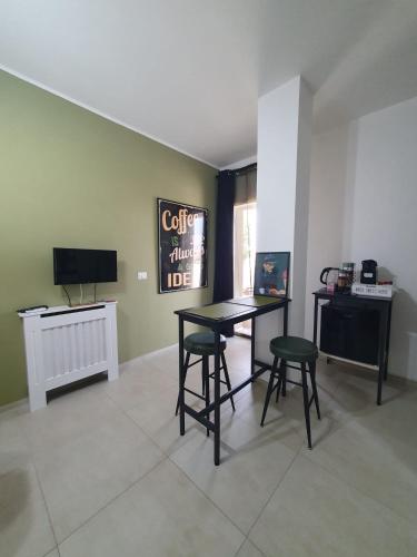 een kamer met een tafel, twee stoelen en een televisie bij Villa Desy in Quartu Sant'Elena