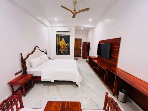 a bedroom with a bed and a flat screen tv at Ramas Palace in Luhāra