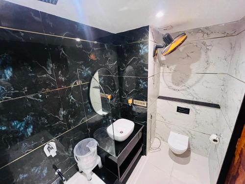 a black and white bathroom with a toilet and a sink at Ramas Palace in Luhāra