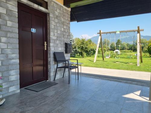 a porch with a wooden door and a table and chair at Rooms & Apartments Jana in Cerklje na Gorenjskem