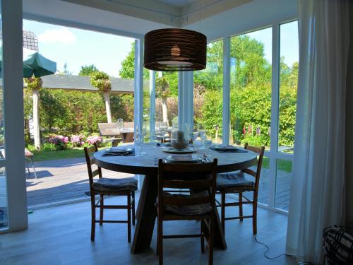 a dining room with a table and chairs and a large window at Holiday Home in Noordwijk near the Beach in Noordwijk