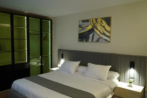 a bedroom with a large bed with two night stands at kornfil guest house in New cairo