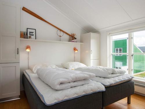 a bedroom with a bed with white pillows on it at Islands Maritime Holiday Village Ebeltoft in Ebeltoft