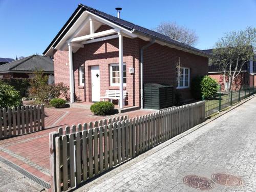 a house with a fence in front of it at Ferienhaus Satelsrönne 23 - Wattlaeufer in Duhnen