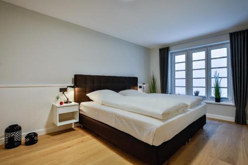 een slaapkamer met een groot bed en een groot raam bij Haus Dock 10 in Westerland